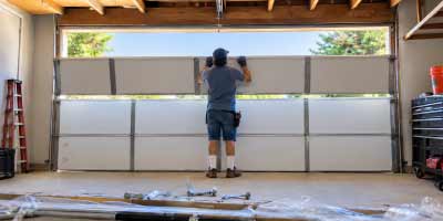 Technician installing a sectional garage door