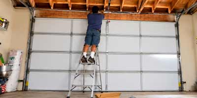 Technician performing garage door maintenance