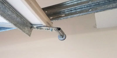 Garage door roller displaced from its track
