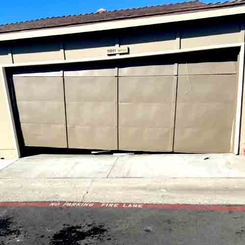 garage door hanging unevenly due to a broken or snapped lift cable