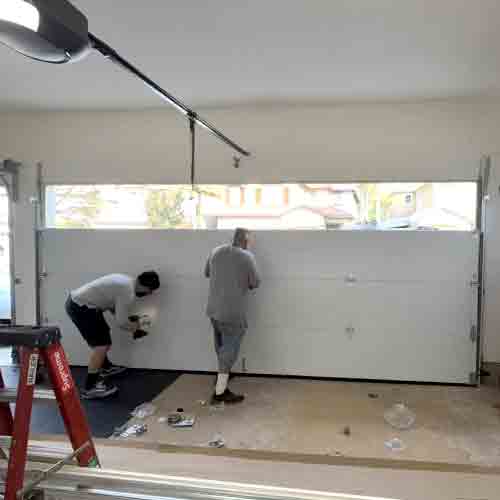 Champion technician installing a multi-layer insulated garage door