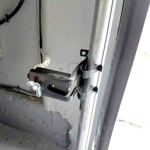 aligning and testing garage door safety sensors, ensuring the system meets necessary safety standards during a maintenance check