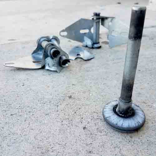 worn roller and broken hinges identified by a technician during a maintenance service