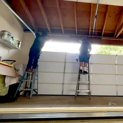 Garage door technician adjusting door hardware during a residential repair in Orange County