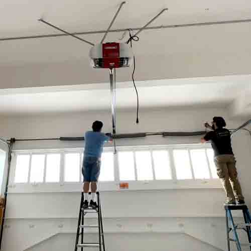 Champion Garage Door technicians installing high-cycle heavy-duty springs calibrated for the weight of a custom wood garage door