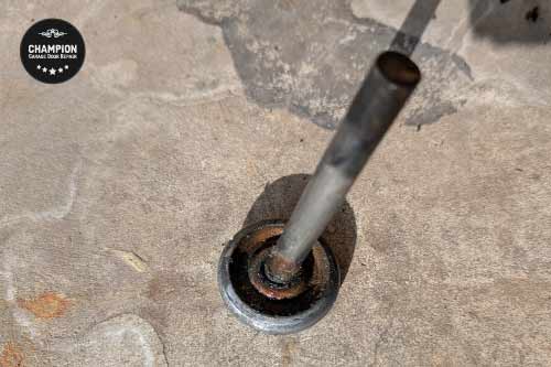 Worn roller with sand and debris buildup in HB coastal environment