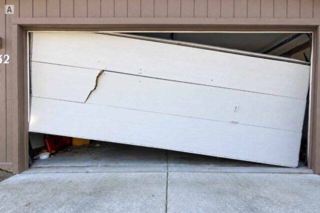 Garage Door Off Track and Crooked Garage door hanging crooked and off track with a damaged door section