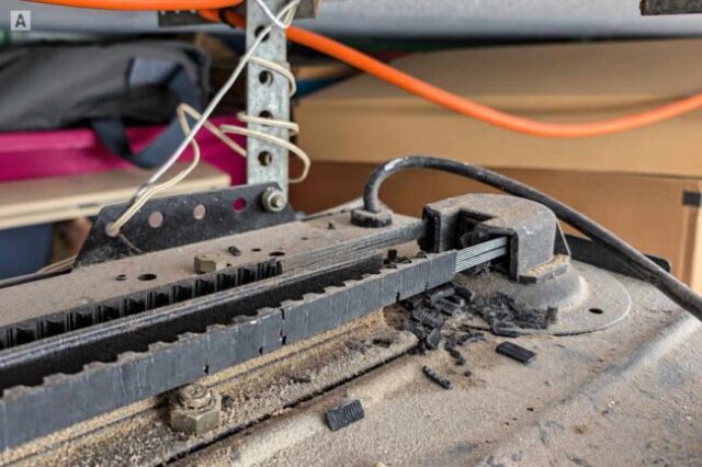 Garage Door Opener Belt Repair Broken garage door opener belt with damaged belt material around the drive assembly