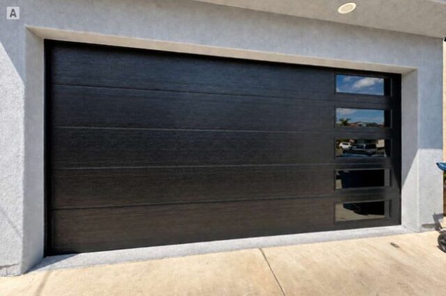 New black garage door with side windows after installation in Costa Mesa