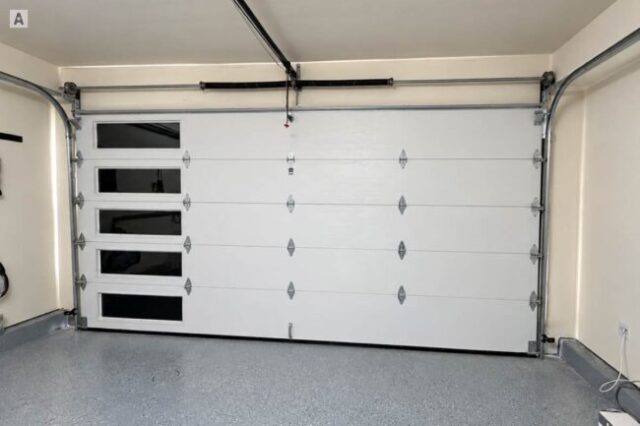 Exterior view of new black garage door after installation in Costa Mesa