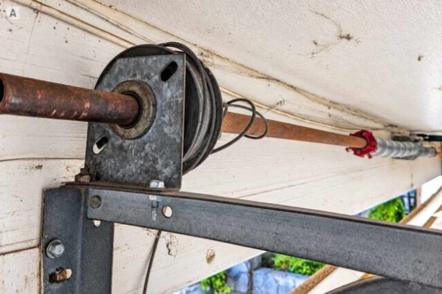 Garage door cable off the drum near the bearing and torsion shaft assembly.