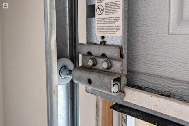 New silent nylon garage door roller installed in the track after replacement