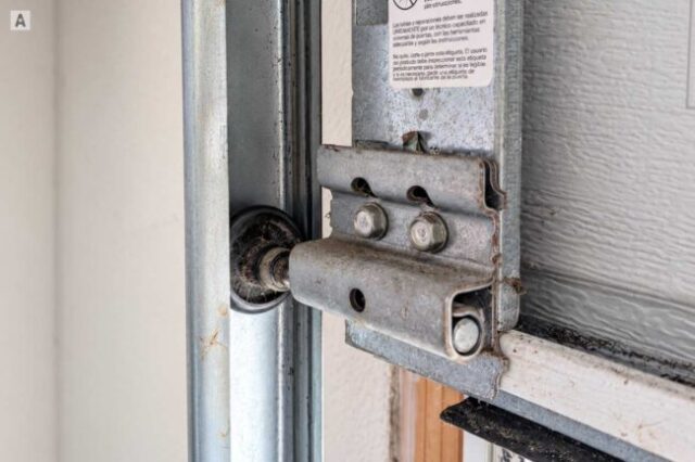 Worn plastic garage door roller in the track before replacement