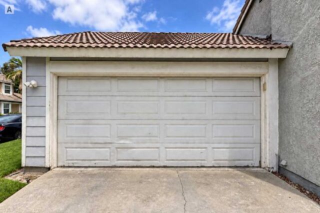 Damaged garage door before replacement in Huntington Beach