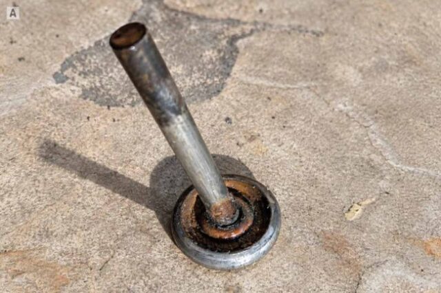 Removed worn garage door roller with a rusted bearing and stem