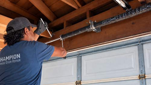 Champion technician working on a garage door spring